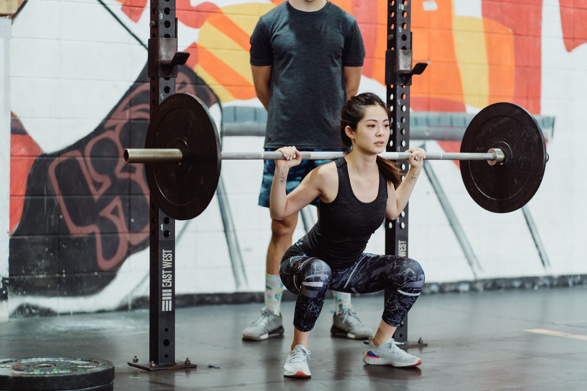 A Kalos coach spotting a client's barbell squat
